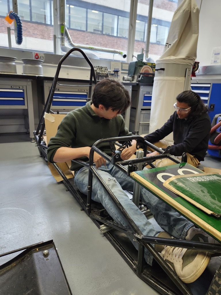 XElectric students learning and working together inside the car chassis
